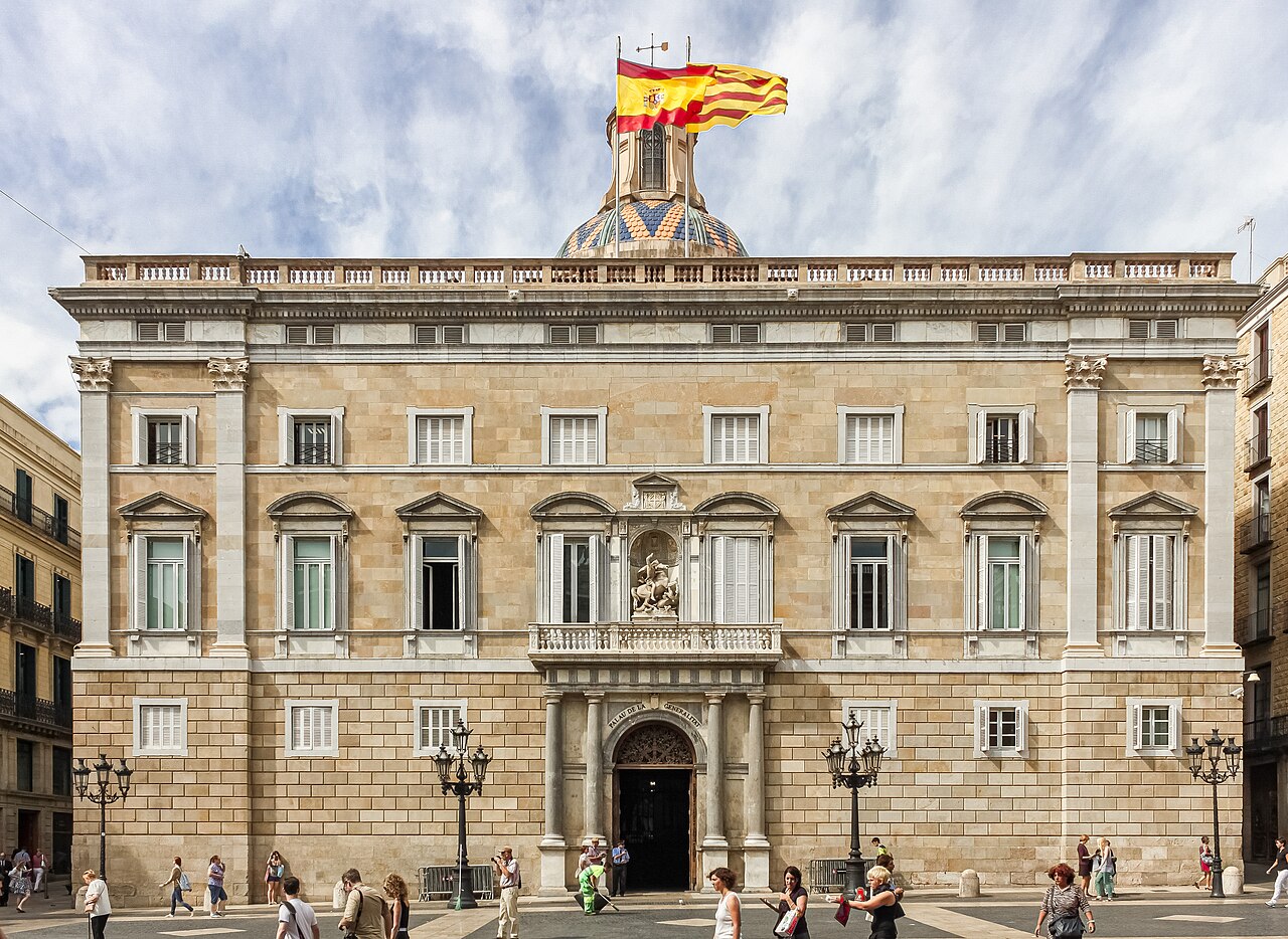 Fotografía de archivo · Fachada neoclásica de edificio institucional con escudo en la cúpula y banderas españolas ondeando